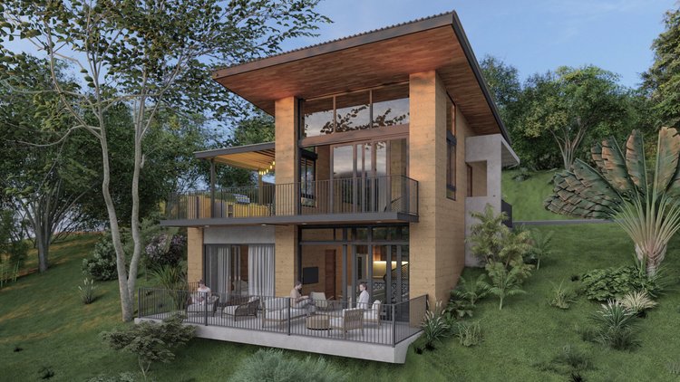Modern house with large glass windows and balconies nestled on a hillside surrounded by trees and greenery.