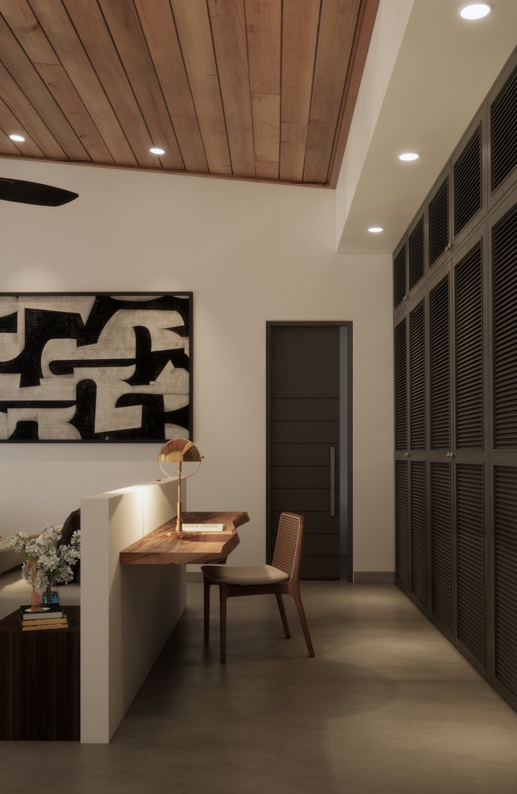 A modern interior space with a wooden ceiling, white walls, a decorative black and white abstract artwork, a built-in desk with a table lamp and a chair, large black louvered cabinets, and a dark door.