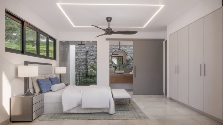 Modern bedroom with a large window, white bed, blue and gray pillows, bedside lamps on a gray nightstand, a bench at the foot of the bed, and an open closet with white doors. There is a bathroom with a textured stone wall, a round mirror, and bathroo