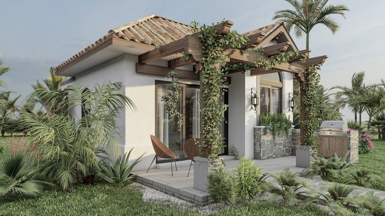 A modern house with a white exterior, glass sliding doors, and a tiled roof. There is a small porch with two chairs and string lights on the wall. The house has greenery and plants around, with a barbecue grill on the patio, and palm trees in the background.