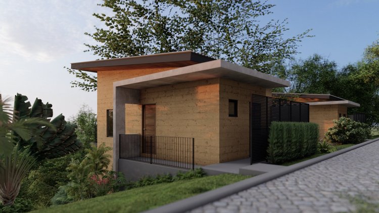 Modern house with beige brick exterior, flat roof, black window shutters, and a small front porch with a railing, surrounded by lush greenery and trees under a partly cloudy sky.