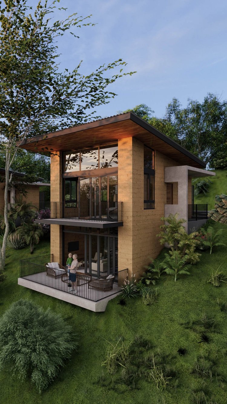 Modern two-story house with large windows, balconies, and outdoor seating area surrounded by greenery.