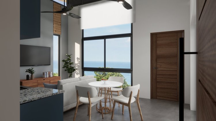 Modern living room with large windows overlooking the ocean, a round white dining table with four chairs, a white sofa, a wooden TV stand with books and decor, a potted plant, and a ceiling fan.